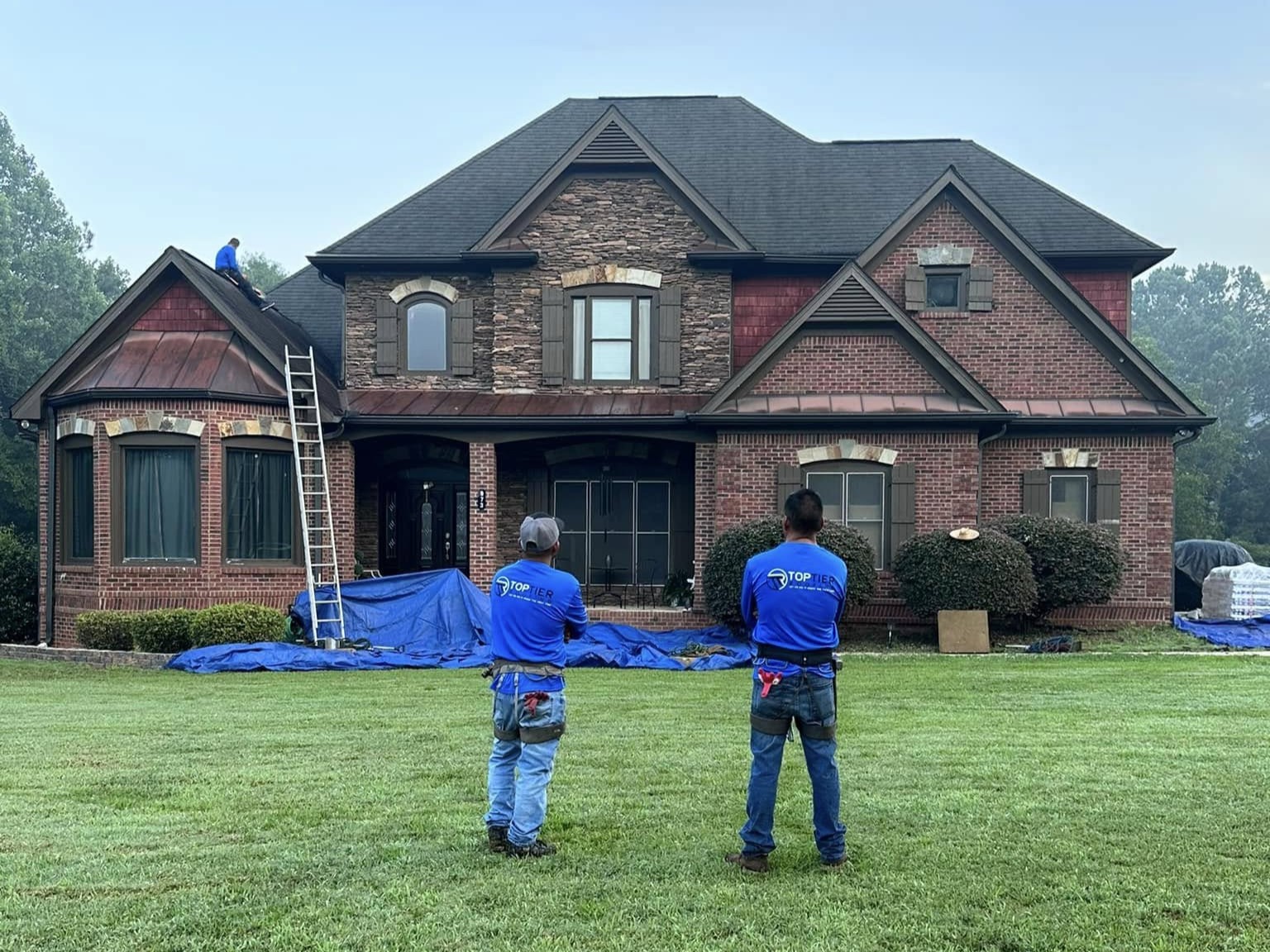 Top Tier team members in front of a house